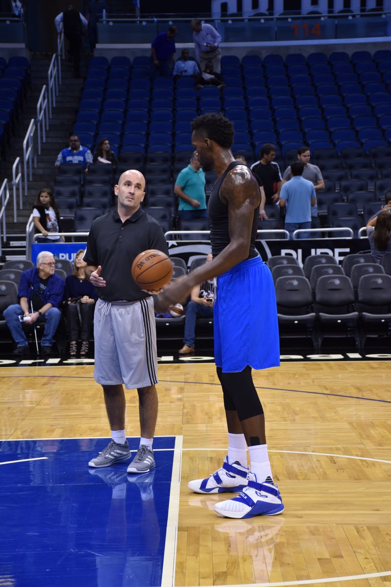 Coach Dave Love and Dewayne Dedmon on the Orlando Magic court before a game.